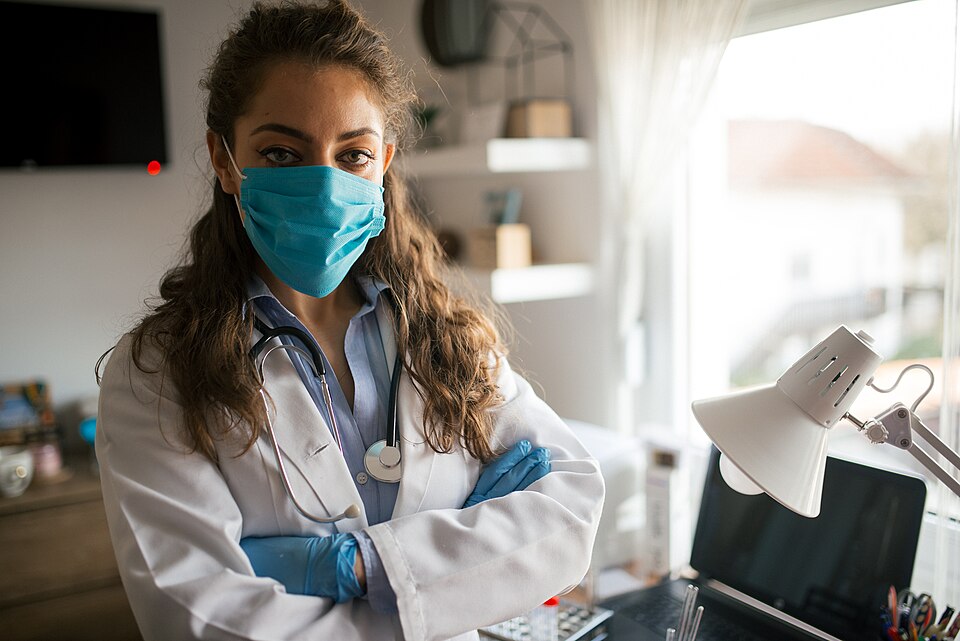 Médecin en blouse blanche dans son cabinet de consultation