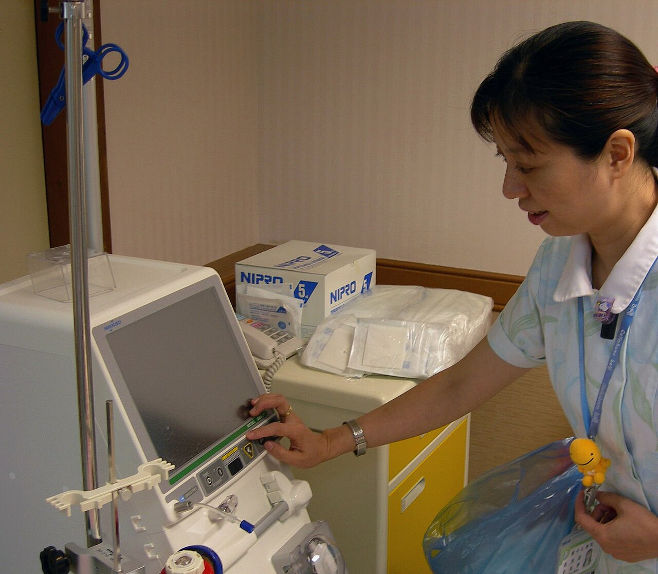 Infirmière devant une machine d'hémodialyse